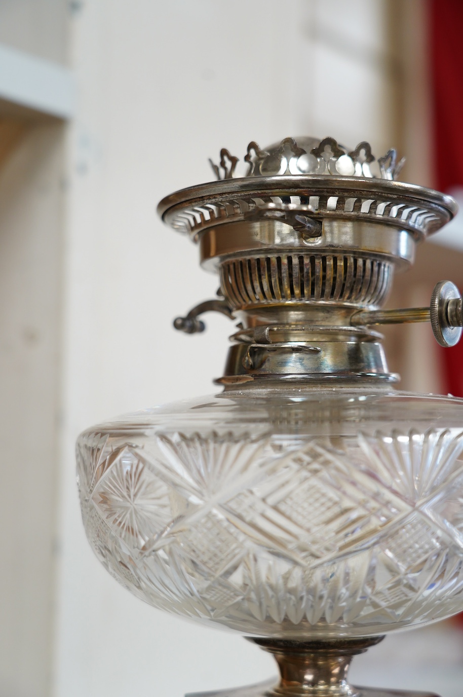 A silver plated oil lamp in the form of a Corinthian column with cut glass reservoir, 76cm high. Condition - fair to good, missing chimney and shade